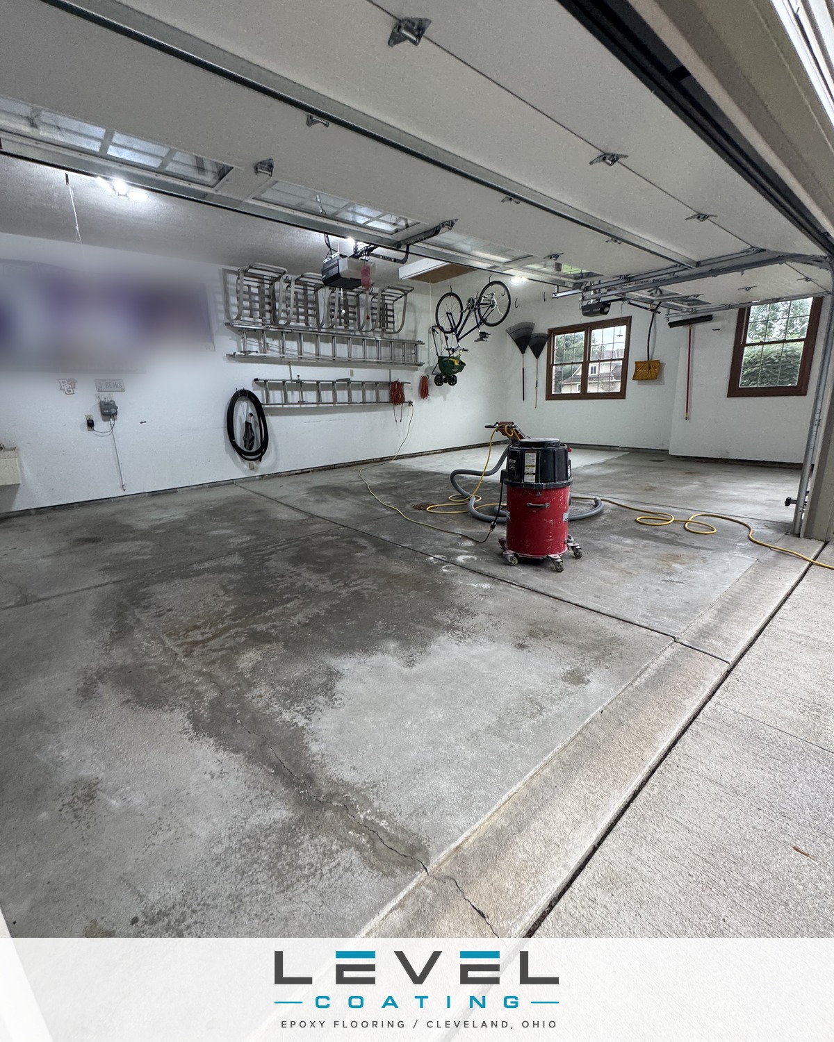 Bare, stained concrete in a three-car garage before coating - Broadview Heights, OH