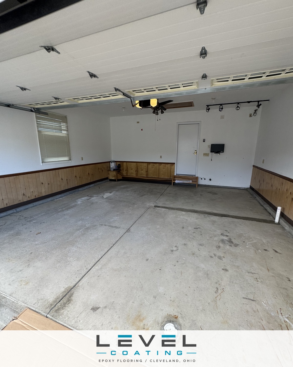 Bare, stained concrete garage floor before coating - North Royalton, OH